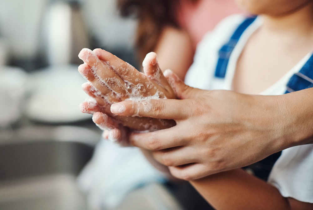 Closeup of adult helping a child wash their hands