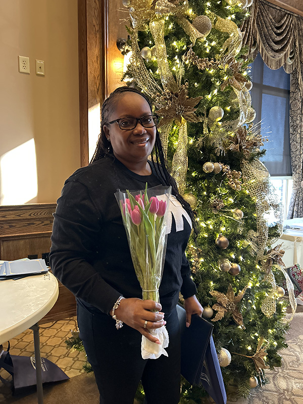 Tamiko Cobb, customer service representative at Rockdale Health Center, is pictured in front of a decorated pine tree after receiving the Tulip Award at GNR Public Health